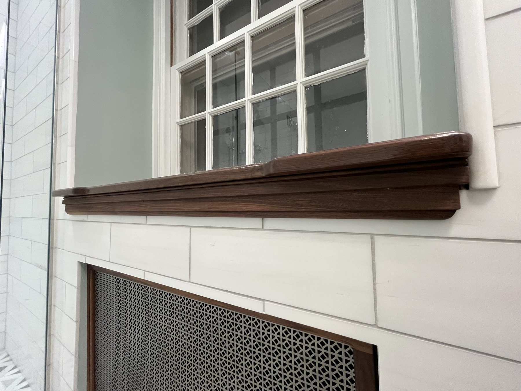 Shaped wood window stool and apron above a radiator grille