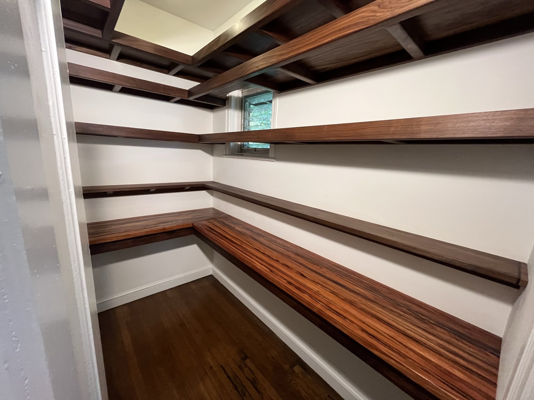 Walnut pantry shelving wrapping around the room above curupay counters