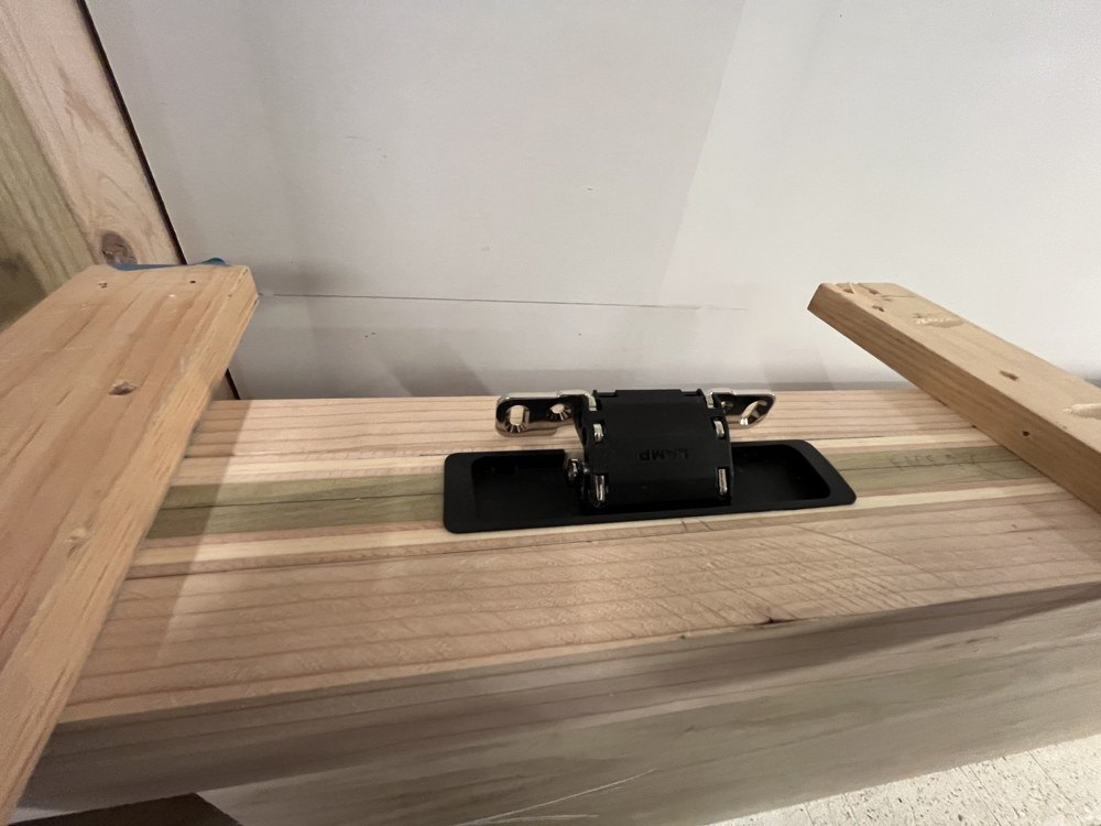 Recessed black hinge hardware fitted into an oak door frame