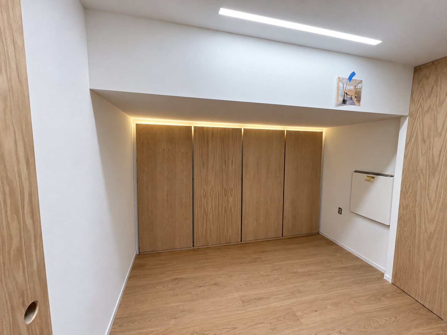 Oak end-wall panels beneath a continuous band of light