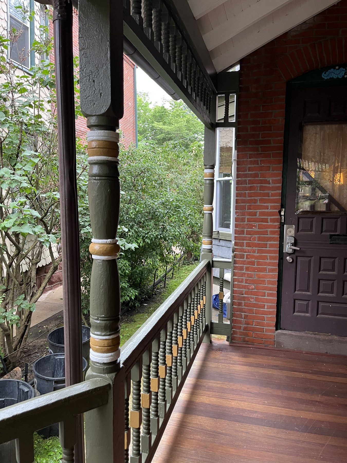 Restored turned porch post with contrasting painted bands beside the entry